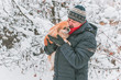 © T.Den_Team - Senior man dog lover with his red pekingese pet on a walk at snowy park. Concept love and care of animals. Good people caring for pets