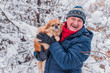 © T.Den_Team - Senior man dog lover with his red pekingese pet on a walk at snowy park. Concept love and care of animals. Good people caring for pets