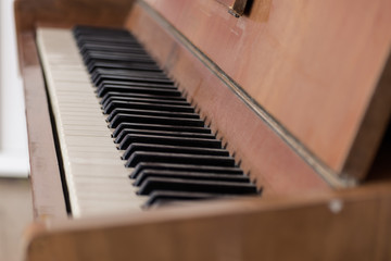 Keys of an old wooden piano. Piano keys on wooden brown musical instrument