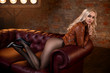 Beautiful blonde girl in pantyhose posing on the sofa.