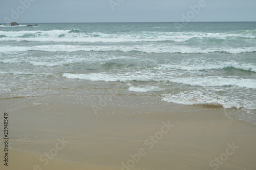 фотография Waves Breaking With White Sand On The Beach Of El Aguilar On A Rainy Day