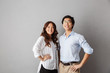 © Drobot Dean - Confident asian couple standing over gray background