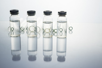 Group of vials with medication on blue methacrylate table.