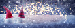 Two Christmas gnomes in the snow in front of lights, banner