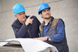 © goodluz - Workman pointing and showing something to employee on modern building sight