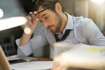 Handsome businessman working late at night in modern office