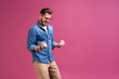 © opolja - Portrait of a satisfied young man celebrating success isolated over pink background.