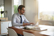 © goodluz - Attractive businessman typing on laptop in modern office
