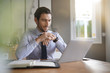 © goodluz - Handsome businessman working on laptop in modern office