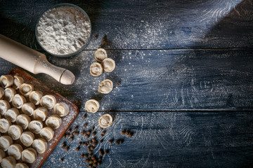  Pelmeni, ravioli, dumplings with meat on dark wood background. Fresh dough.