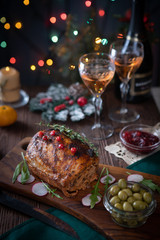 Grilled pork loin on the Christmas table with Christmas lights in the background