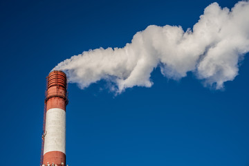 industrial smoke from chimney on blue sky