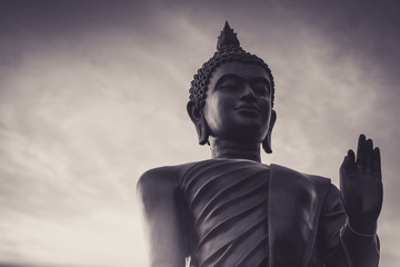 Dark tone portrait black buddha statue and sky on background in Thailand.