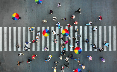 Aerial. People crowd on a pedestrian crossing crosswalk. View above.