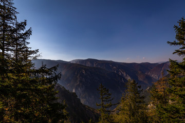 Wall Mural - Scenic view from top of the Stadelwand grad to Rax valley, with grass, rocks and dark blue sky, Alpen, lower Austria