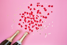 Valentines Day Background. Two Champagne Bottles With Red Hearts And Golden Confetti On Pink Background. Copy Space, Top View, Flat Lay.