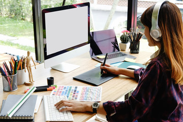Wall Mural - young female designer drawing sketches on digital graphic draw tablet at studio.