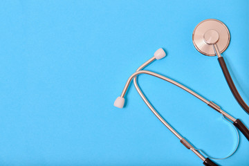 Black stethoscope isolated on blue background