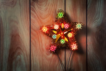 Vintage Lighted Christmas Star Hanging On Wood Paneling