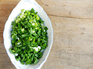 Canvas Print - fresh spring onion chopped green onions on wooden background