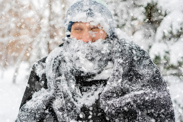 close up portrait of frost man face covered by snowy scarf and hat outdoor, winter concept f