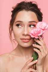 Canvas Print - Pretty young woman posing isolated over pink wall background with flowers.