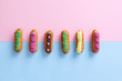 French eclairs on pink and blue divided background. Top view with copy space