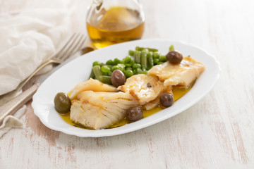 Wall Mural - fried cod fish with peas and green beans on white dish