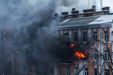 Odessa, Ukraine - Dec. 29, 2016: A Fire In An Apartment Building. Strong Bright Light And Clubs, Smoke Clouds Window Of Their Burning House. Firefighters Extinguish Fire In House. Work On Fire Stairs