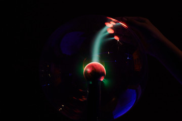 plasma ball lamp energy, hand touching glowing glass sphere concept for power, electricity, science 