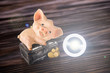 Led lamp and piggy bank lie on a wooden background