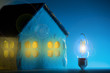 Silhouette led lamp against layout of the house on a blue background