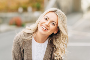 outdoor portrait of happy smiling woman with blonde hair