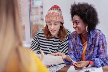 Two cheerful students of art school feeling happy together