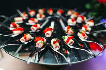 Beautifully decorated catering banquet table with profiteroles, salads and cold snacks. Variety of tasty delicious snacks on the table. Wedding table serving. Meat and vegetables