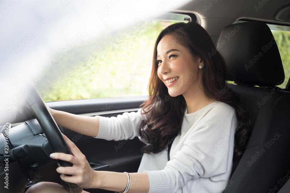 Asian women driving a car and smile happily with glad positive expression during the drive to travel journey, People enjoy laughing transport and relaxed happy woman on roadtrip vacation concept - obrazy, fototapety, plakaty 