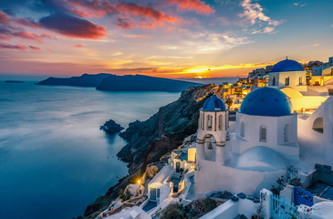 Fototapete - Beautiful view of Churches in Oia village, Santorini island in Greece at sunset, with dramatic sky.