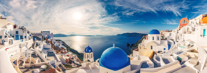 Fototapete - Churches in Oia, Santorini island in Greece, on a sunny day with dramatic sky. Panorama view.