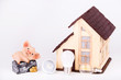 Led lamps and piggy bank lie near the house layout on a white background.