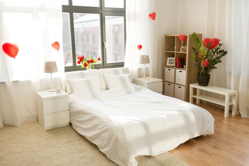 coziness, interior and romantic date concept - cozy home bedroom decorated for valentines day