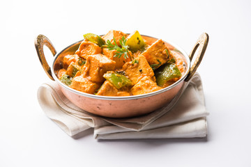 Wall Mural - Malai or achari Paneer in a gravy made using red gravy and green capsicum. served in a bowl. selective focus