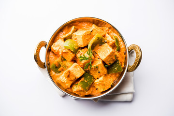 Canvas Print - Malai or achari Paneer in a gravy made using red gravy and green capsicum. served in a bowl. selective focus