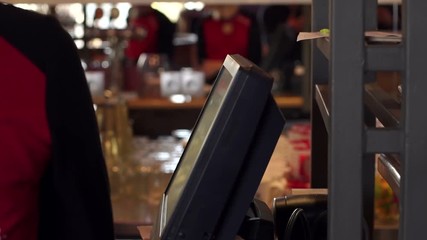 Close-up of the waiter's hand on the touch screen in the cafe, registration and payment of the order. Hand of the waiter near the working touch screen monitor.