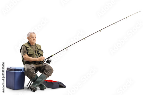 Fotomural Fisherman sitting on a chair with a fishing rod
