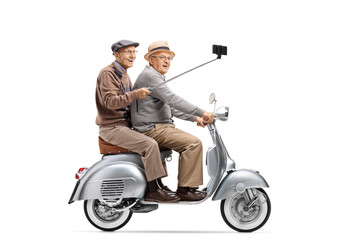 Sticker - Two senior men riding on a vintage scooter taking a selfie with a stick