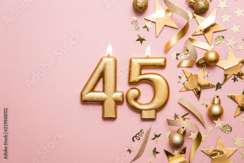 Photographie Number 45 gold celebration candle on star and glitter background