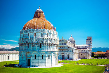 Wall Mural - Baptistery of St. John on Square of Miracles, Leaning Tower, famous inclined tower of Pisa with green lawn in Pisa, Tuscany, Italy