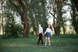© soleg - young couple walking in the forest and playing guitar, summer nature, bright sunlight, shadows and green leaves, romantic feelings