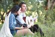 © soleg - young couple sitting in the forest and playing guitar, summer nature, bright sunlight, shadows and green leaves, romantic feelings