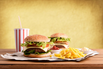 Wall Mural - Two burger with soda and chips with souces on table